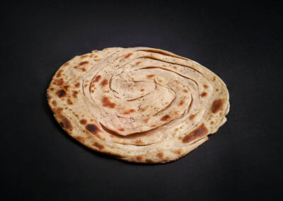 46.  Lachaa Parantha /55,-  Ugjæret grov brød fylt med smør og bakt i tandoor. Butter layered whole-wheat flour bread baked in tandoor. *Lactose, Gluten